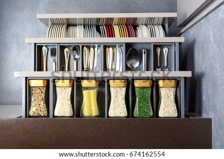 Modern kitchen countertop with food ingredients. Top view of drawers with spices organized inside.