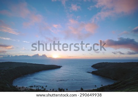 The sun rising over a beautiful bay as seen from a high vantage point on a mountain on the eastern shore of Oahu, Hawaii.