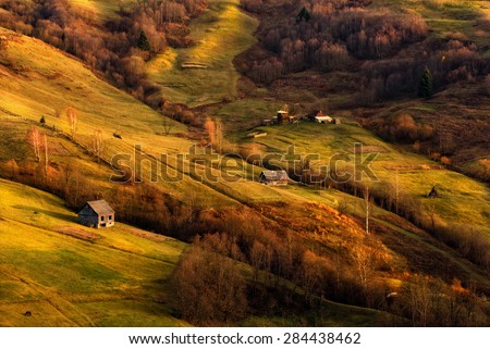Autumn evening. The last rays of the sun fall on the slopes. Carpathian  rolling landscape on sunset in autumn colors. West Ukraine