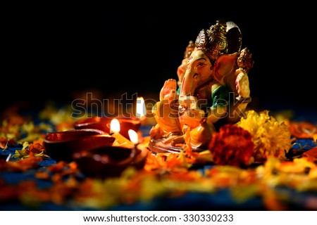 Clay diya lamps lit with Lord Ganesha during diwali celebration. Greetings Card Design Indian Hindu Light Festival called Diwali