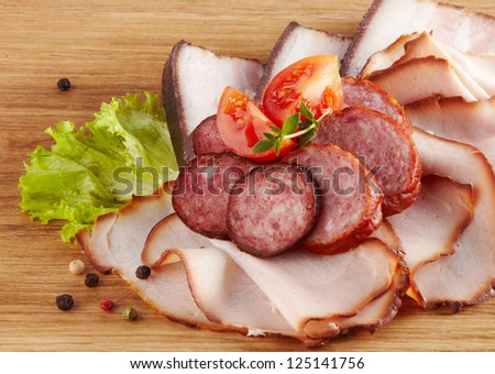 smoked meat and sausages on wooden cutting board