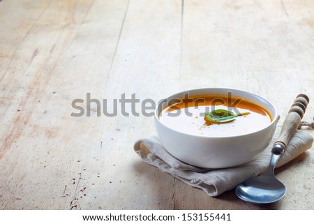 bowl of squash soup on a wooden table