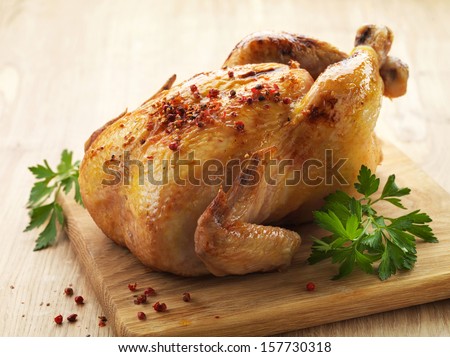Roast chicken and parsley on wooden cutting board Roast chicken and parsley on wooden cutting board