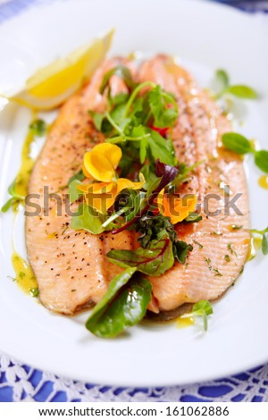 steamed trout and beet leaves on white plate