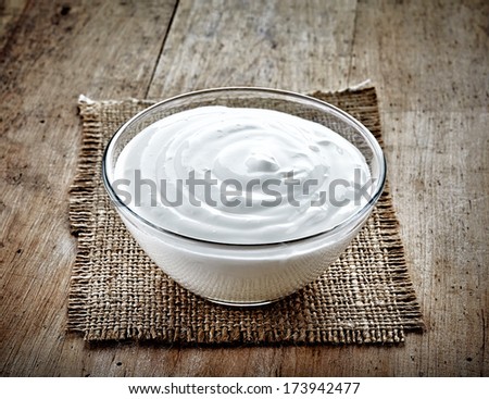 Bowl Of Sour Cream On Old Wooden Table