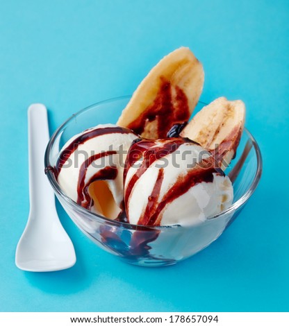 ice cream with banana and chocolate sauce in a bowl