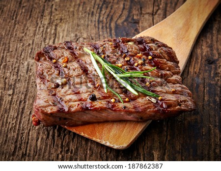 grilled beef steak on wooden cutting board