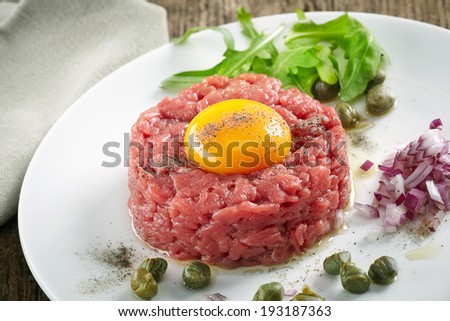 fresh beef tartar with egg on white plate