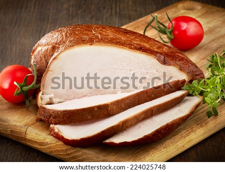 sliced smoked chicken breast on wooden cutting board