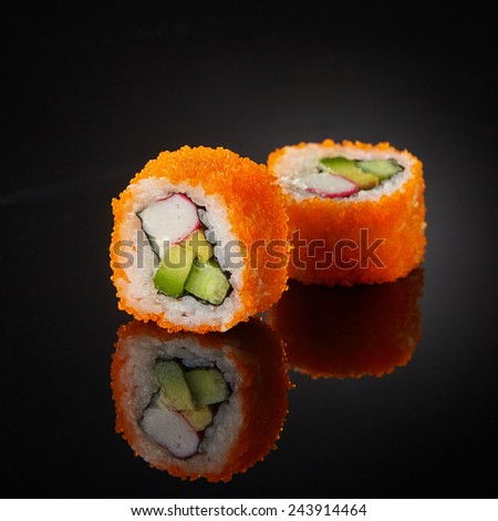sushi with cucumber and crab sticks on black background