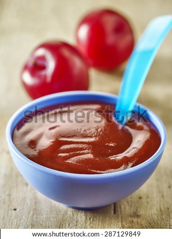 plums puree in a plastic bowl