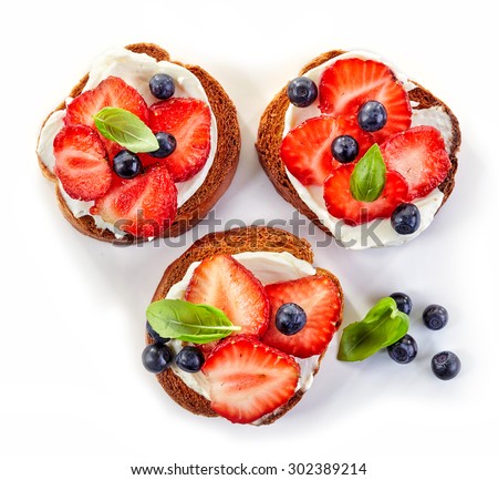 toasted bread with cream cheese and berries isolated on white background, top view