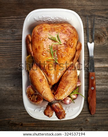 roasted chicken with vegetables on wooden table, top view