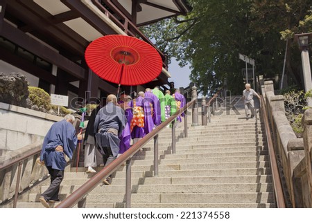Narita, Japan - August 2, 2014: Buddhist priests in Narita walk over to the temple to perform a traditional praying ritual in Japan.