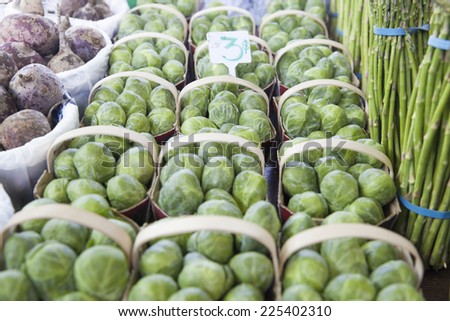 Brussels Sprouts for Sale at the Market - Shot of a several baskets of brussels sprouts for sale at a farmers market among other fresh vegetables.