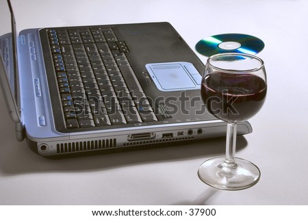 Laptop computer with glass of wine and CD.