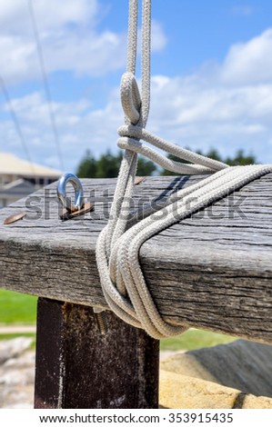 Flag Rope Lines knotted to wooden post and a blue sky/Flag Lines/Knotted Detail