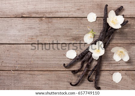 Vanilla sticks with flower and leaf on a old wooden background with copy space for your text. Top view
