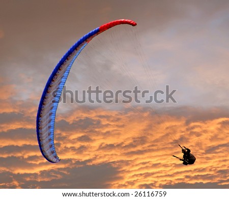 A man making a parachute jump in the sunset