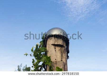 Helmet on the stump and green leaves , blue sky background soft cloud ,blue sky background