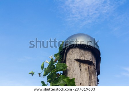 Helmet on the stump and green leaves , blue sky background soft cloud