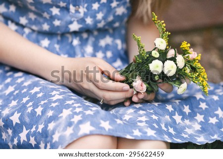 beautiful female hand with a bouquet of wildflowers