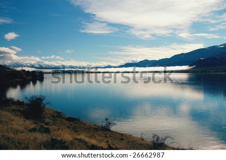 Calm morning on a lake in New Zealand with Southern Alps in the background