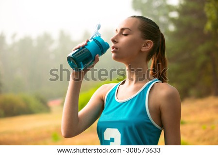The girl is tired after a long running, and decided to have a drink of water. She wants to quench her thirst.