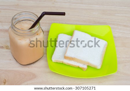 Ice milk tea and bread on wooden table