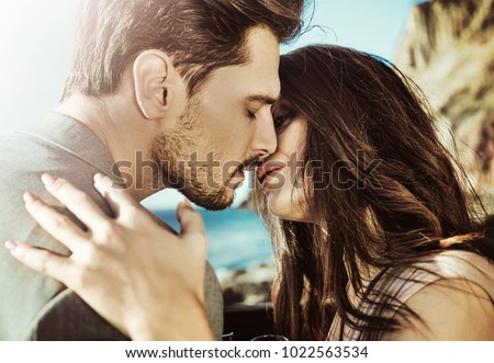 Elegant man man posing with his girlfriend on a beach