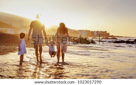 Happy family enjoying sunset in the summer leisure