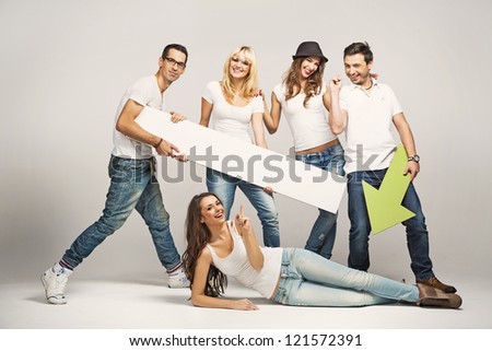 Group of cheerful young people holding empty board
