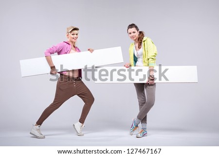 Two young women holding white boards