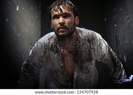 Dirty man between grunge walls - stock photo