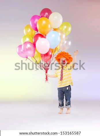 Small boy holding bunch of balloons