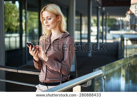 Young blonde lady with a smartphone