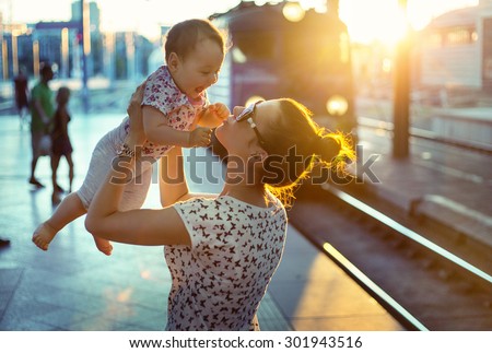 Young mother holding her baby on a train station