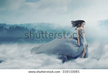 Magical brunette lady on a foggy field