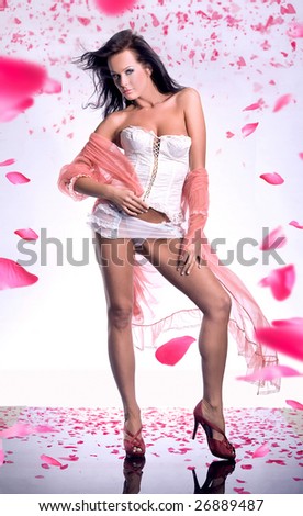 Gorgeous glamour girl with a long voile over rose petals