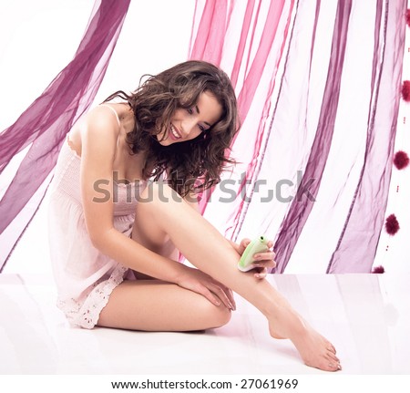 Young beautiful woman shaving her legs