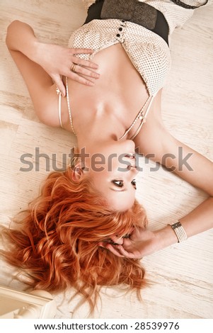 Redhead young woman lying on the floor