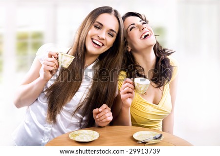 Two smiling girls have coffee time