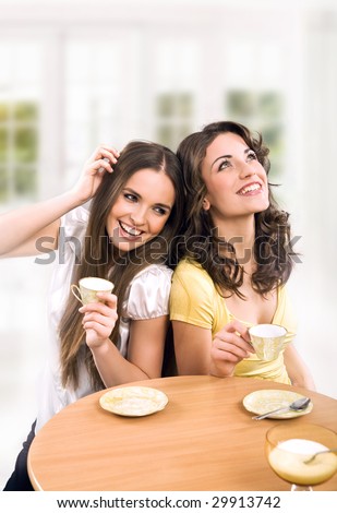 Two beautiful women drinking coffee and chatting