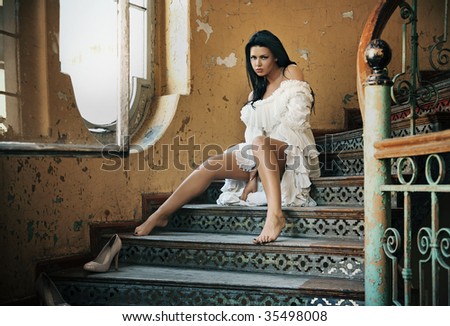 Beautiful brunette posing in on vintage stairs
