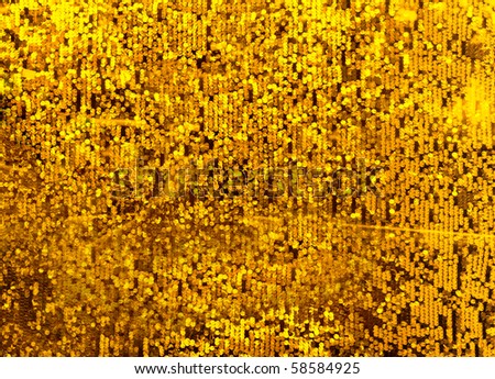 Gold flakes or golden dust on black background - abstract
