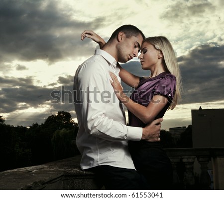 stock photo Beautiful couple hugging over cloudy sunset