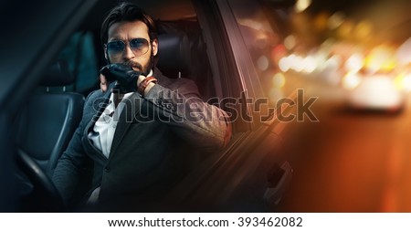 Outdoor portrait of elegant man driving a car