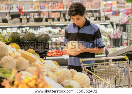 Young man buying fruits in supermarket