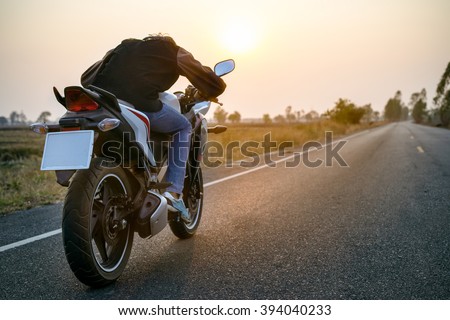 Asian man driving motorcycle