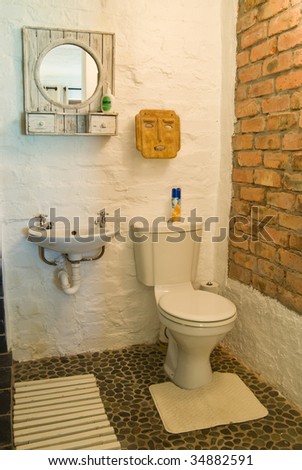 Guest house bathroom with a toilet, mirror and basin